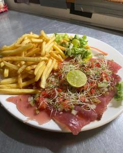 un piatto di cibo con patatine fritte, carne e un'insalata di Tropical Place a HUH