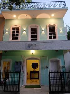 une maison blanche et verte avec un porche d'entrée dans l'établissement Nautical Escape Home Stay, à Pondichéry