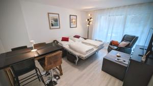 a living room with a bed and a desk and a room with a desk at Souterrain Casa Siegburg in Siegburg