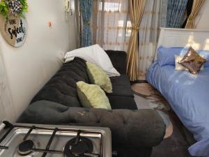 un salon avec un canapé et un lit dans l'établissement Flo Steve Stays, à Nairobi
