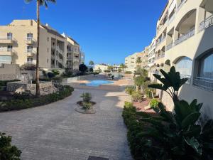 a walkway next to a building with a swimming pool at casa kayla in Palm-Mar