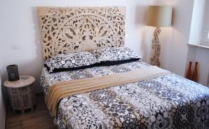 una camera da letto con letto, testiera e cuscini di Festina Lente B&B a Porto Recanati
