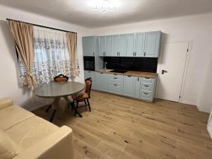 a living room with a table and a kitchen at Casa Romanța in Cehu Silvaniei