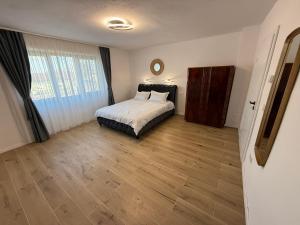 a bedroom with a bed and a large window at Casa Romanța in Cehu Silvaniei