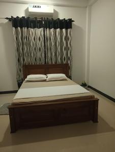 een groot bed in een slaapkamer met een gordijn bij S & S Homestay in Walliwala East