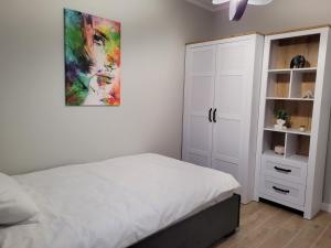 - une chambre avec un lit et une armoire blanche dans l'établissement Axo-Hostel 1, à Stalowa Wola