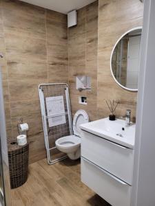 une salle de bains avec toilettes, lavabo et miroir dans l'établissement Axo-Hostel 1, à Stalowa Wola