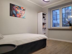 une chambre avec un lit et un tableau au mur dans l'établissement Axo-Hostel 1, à Stalowa Wola