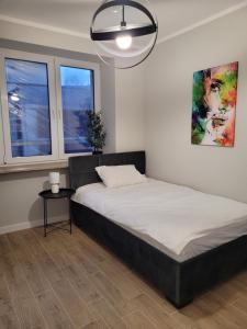 une chambre avec un lit et un lustre dans l'établissement Axo-Hostel 1, à Stalowa Wola