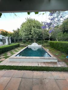 a pool of water in a garden with trees at Kleinhof in Franschhoek