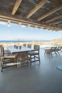 een tafel en stoelen op een terras met uitzicht bij Oskelos in Kastraki Naxou