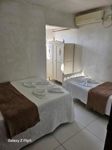 a room with two beds and a cabinet in it at Pousada Tereza in Piranhas