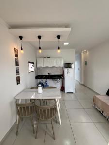 a kitchen and dining room with a table and a refrigerator at Pôr do Sol - Serraruna in Araruna +10 photos