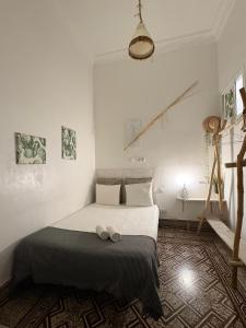 een slaapkamer met een bed met twee schoenen erop bij Cactus Host in Las Palmas de Gran Canaria