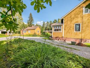 a house with a yellow building and a yard at A little home in Lahti