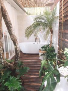 een badkamer met palmbomen en een ligbad bij Thung Lũng Sun View homestay in Xuan An