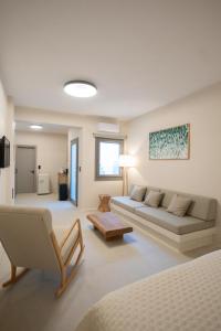 een grote woonkamer met een bank en een tafel bij Oskelos in Kastraki Naxou