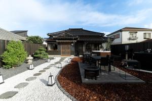een terras met een tafel en stoelen voor een huis bij 陽和リトリート in Tateyama