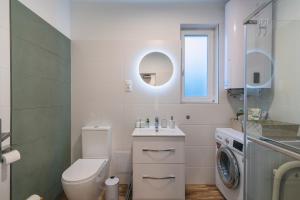 a bathroom with a toilet and a sink and a washing machine at Fácán Fészek Vendégház in Mátraszentimre +21 photos
