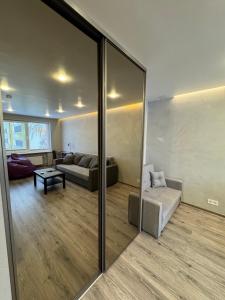 a living room with a mirror and a couch at Apartment near the sea-Sigulda street in Liepāja