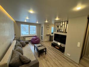 a living room with a couch and a tv at Apartment near the sea-Sigulda street in Liepāja