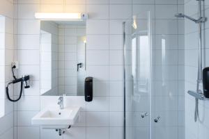 un bagno bianco con lavandino e doccia di Citybox Oslo a Oslo