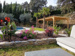 een tuin met een stenen muur en een pergola bij La única in Coín
