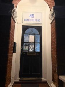 een zwarte voordeur van een gerenoveerde weg bij Rayan's Lodge Stratford London by OYO in Londen