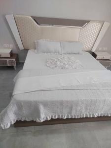 a large white bed with white sheets and pillows at Mwisenix apartment in Kigali +12 photos