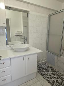 un bagno bianco con lavandino e specchio di Mon superbe appartement ad Argenteuil Altre 22 foto