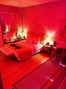 a red bedroom with a large bed and a mirror at LOFT & SPA PRIVATIF in Dijon