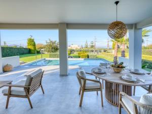 a dining room with a table and chairs and a pool at Villa Alaya in Kos +46 photos