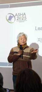 une femme tenant un microphone devant un écran dans l'établissement 小太阳民宿, à Bangkok