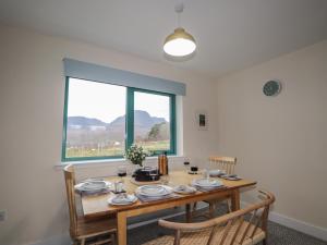 a dining room with a table and a window at Sonas in Strathcarron