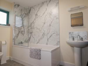 a white bathroom with a sink and a shower at Sonas in Strathcarron +25 photos