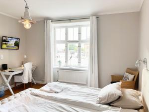 a bedroom with a bed and a desk and a window at Wisby Residence in Visby