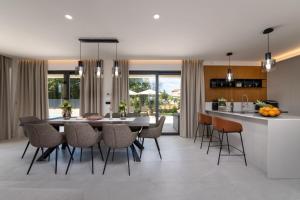 eine Küche und ein Esszimmer mit Tisch und Stühlen in der Unterkunft Villa Perla by Villsy in Rošini