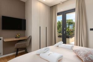 ein Schlafzimmer mit Bett, Schreibtisch und Fernseher in der Unterkunft Villa Perla by Villsy in Rošini + 53 Fotos