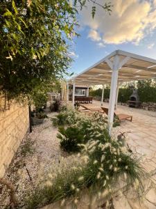 een paviljoen met een picknicktafel onder een luifel bij Cozzo Spadaro B&B OnlyRooms in Portopalo