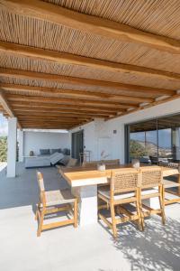 a patio with a wooden ceiling and a table and chairs at Oskelos in Kastraki
