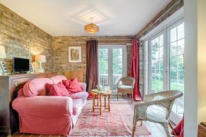 a living room with a pink chair and a couch at 3 Bed in Awre oc-s34503 in Awre