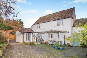 an exterior view of a white house with a courtyard at 3 Bed in Awre oc-s34503 in Awre