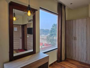 een badkamer met een grote spiegel en een groot raam bij Hotel The SOHO in Chandīgarh