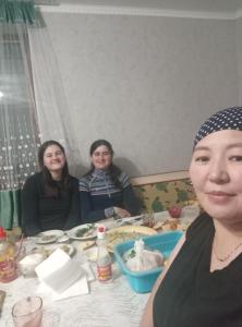 a group of three women sitting at a table at Guest house grizzly in Dzhergalan