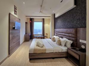 a bedroom with a large bed with a wooden headboard at Hotel The SOHO in Chandīgarh
