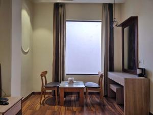 a room with a table and chairs and a window at Hotel The SOHO in Chandīgarh