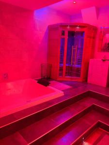a red room with a bath tub and red lights at LOFT & SPA PRIVATIF in Dijon +2 photos