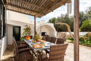 un patio esterno con tavolo e sedie di Finca Biniparrell Vell a Sant Lluís
