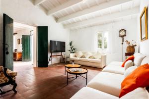 un soggiorno con un divano e un tavolo di Finca Biniparrell Vell a Sant Lluís