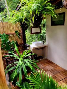 een tuin met een bank en planten in een kamer bij Loki Baan Paa in Ko Kood